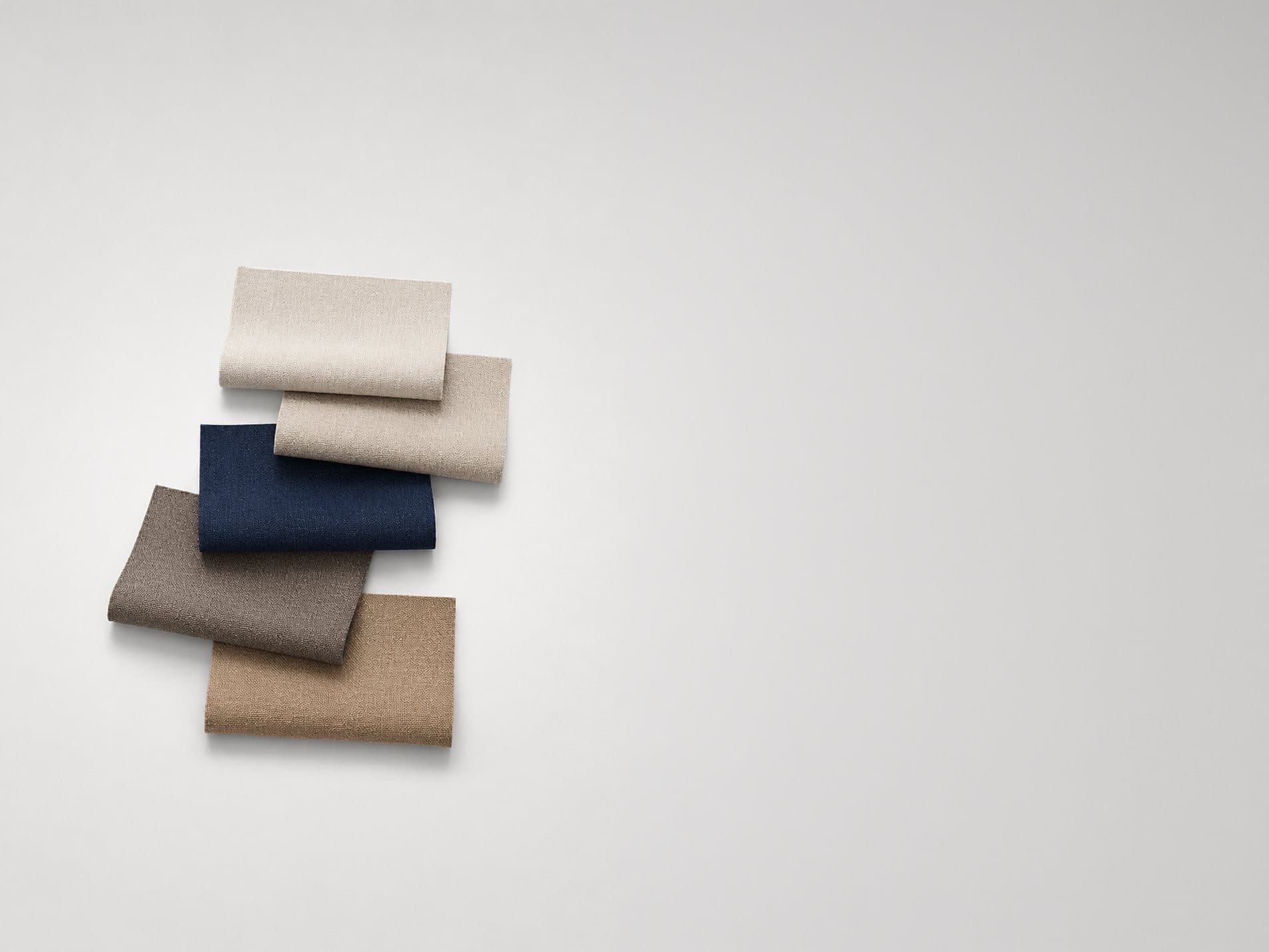 Folded fabric swatches in navy, taupe and ivory